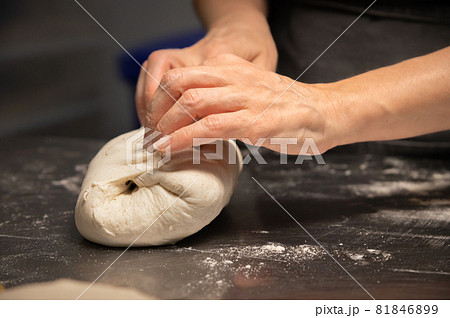 close-up of female hands kneading dough for making artisan bread at home bakery 81846899