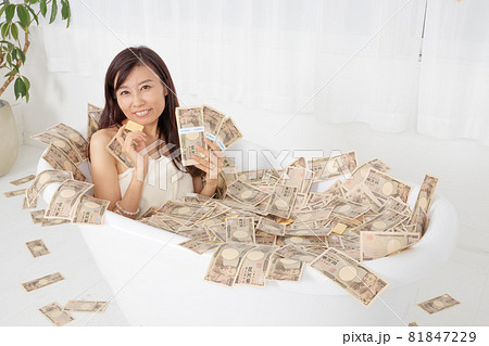 札束や金貨の有る札束風呂に浸かっている女性 札束や金貨の有る札束風呂に浸かっている女性 81847229
