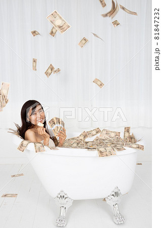 札束や金貨の有る札束風呂に浸かっている女性 81847232