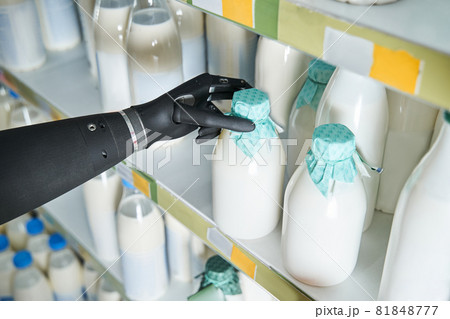 Woman implant hand taking bottle of milk from shelf Woman implant hand taking bottle of milk from shelf 81848777