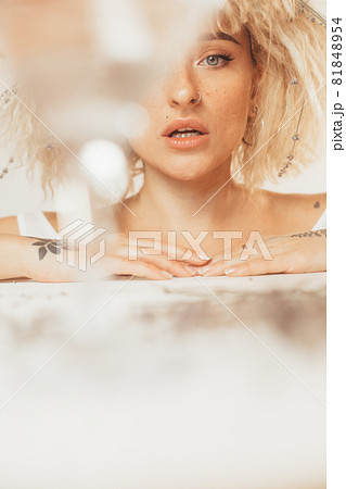 Woman looking from behind the glass while keeping her mouth open Woman looking from behind the glass while keeping her mouth open 81848954