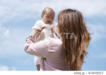 赤ちゃんを高い高いする女性 マスク の写真素材