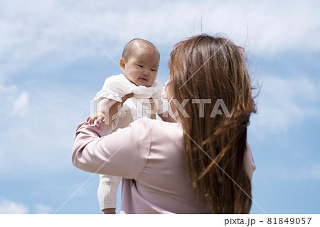 赤ちゃんを高い高いする女性 マスク の写真素材