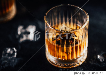 Whiskey with ice on a dark table 81850343