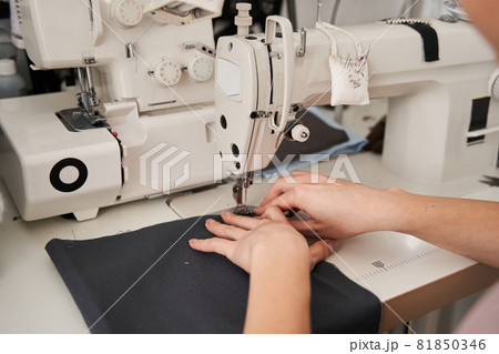Seamstress using sewing machine 81850346