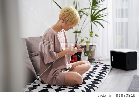 Woman messaging on smartphone at home 81850819