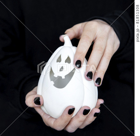 Female hands holding funny pumpkins on black background Female hands holding funny pumpkins on black background 81851308