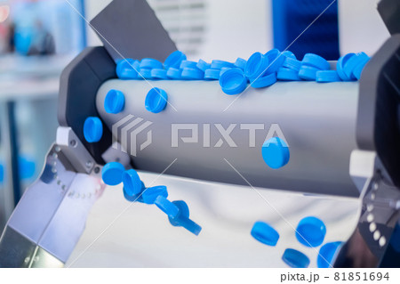 Production line - many blue plastic bottle caps falling from conveyor belt Production line - many blue plastic bottle caps falling from conveyor belt 81851694