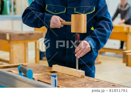 Carpenter using chisel and hammer to carve wood - close up 81851761