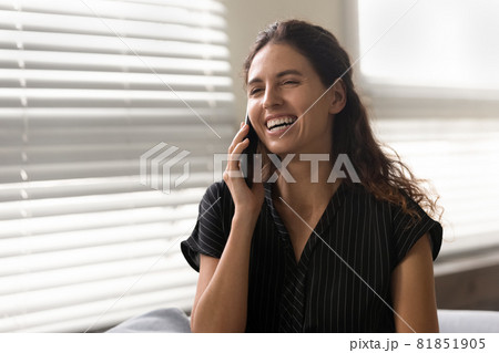 Happy excited Latin woman talking on mobile phone 81851905