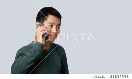 Portrait of Asia man talking smartphone isolated on gray background. Portrait of Asia man talking smartphone isolated on gray background. 81852558