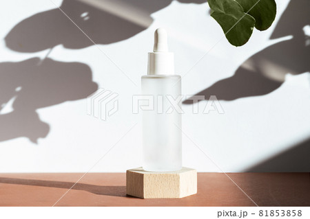 Cosmetic mock up background. Serum with peptides in glass bottle on wooden geometric podium, scene natural plant shadows. Cosmetics product mockup. Skin care concept. Beauty blogging 81853858