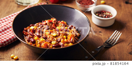 Chili Con Carne with ground beef, beans and corn in dark bowl on wooden background. Mexican and Texas cuisine 81854164