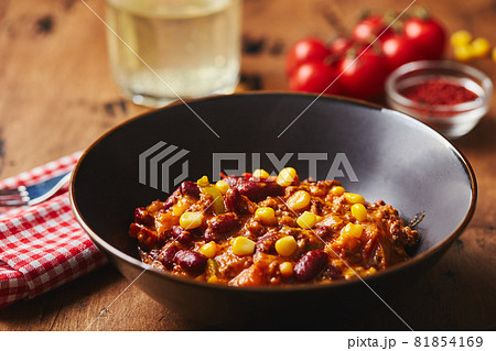 Chili Con Carne with ground beef, beans and corn in dark bowl on wooden background. Mexican and Texas cuisine Chili Con Carne with ground beef, beans and corn in dark bowl on wooden background. Mexican and Texas cuisine 81854169