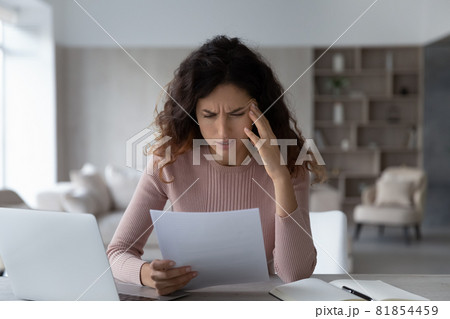 Unhappy depressed young latin woman reading letter with bad news. Unhappy depressed young latin woman reading letter with bad news. 81854459