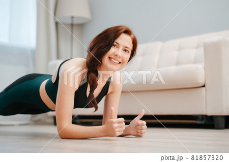 Happy woman does yoga on the floor. 81857320