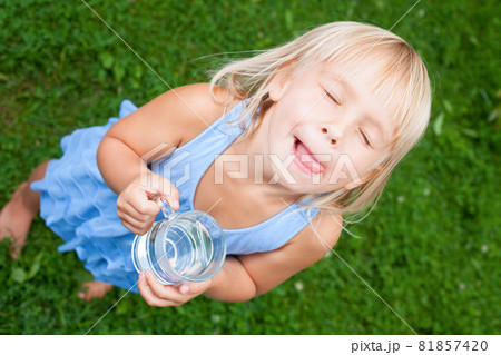 Child enjoy drinking water outdoors Child enjoy drinking water outdoors 81857420
