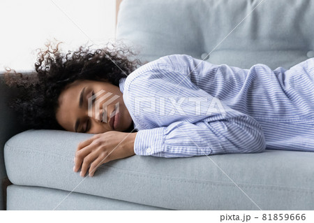 Exhausted millennial african american woman fall asleep on couch Exhausted millennial african american woman fall asleep on couch 81859666