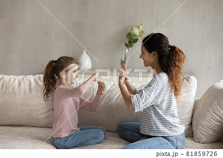 Adorable girl practicing communication with caring mum. Adorable girl practicing communication with caring mum. 81859726