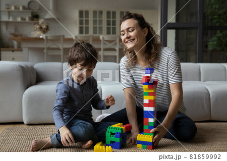 Happy mom helping son to build toy tower from blocks, Happy mom helping son to build toy tower from blocks, 81859992