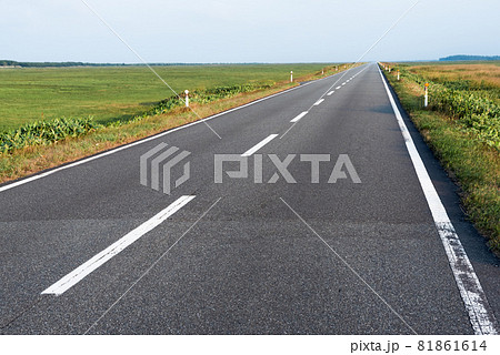 地平線まで伸びる果てしなく続く直線道路 北海道猿払村 エヌサカ線の写真素材