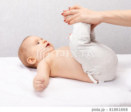 Physiotherapist performing development exercise with little child - baby gym concept 81861668