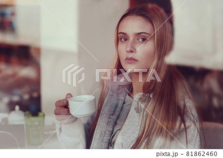 blond long hair girl close up portrait through the cafe window blond long hair girl close up portrait through the cafe window 81862460