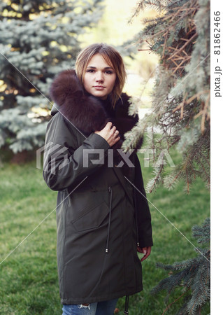 blond business woman in fox fur down jacket with hood closeup photo on city park background 81862466