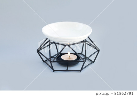 Aroma lamp or oil burner with burning candle and essential oils 81862791