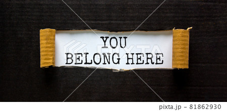 You belong here symbol. Words 'You belong here ' appearing behind torn black paper. Beautiful black background. Business, diversity, inclusion, belonging and you belong here concept, copy space. 81862930