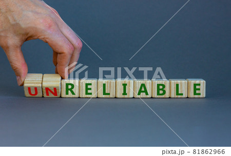 Unreliable or reliable symbol. Businessman turns wooden cubes and changes the word unreliable to reliable. Beautiful grey background, copy space. Business and unreliable or reliable concept. Unreliable or reliable symbol. Businessman turns wooden cubes and changes the word unreliable to reliable. Beautiful grey background, copy space. Business and unreliable or reliable concept. 81862966