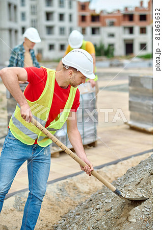 Industrious male worker digging the ground with a spade Industrious male worker digging the ground with a spade 81863632