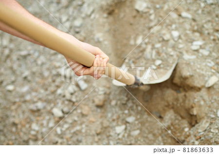 Hand of an experienced builder digging ground using a spade 81863633