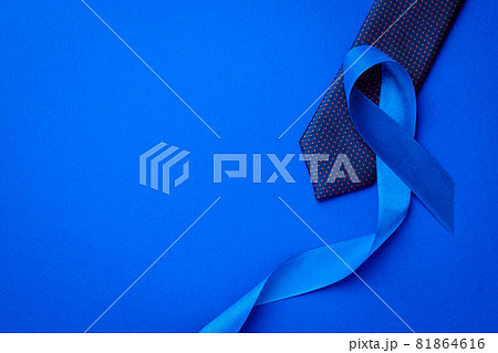Prostate awareness. Blue ribbon, fashion tie isolated on deep blue background. Awareness prostate cancer of men health in November. Healthcare, International men, Father day. Prostate awareness. Blue ribbon, fashion tie isolated on deep blue background. Awareness prostate cancer of men health in November. Healthcare, International men, Father day. 81864616