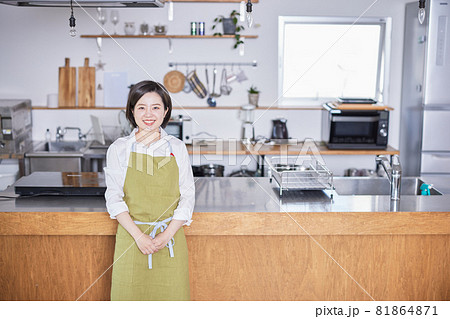エプロンをつけてキッチンに立つ若い女性 エプロンをつけてキッチンに立つ若い女性 81864871