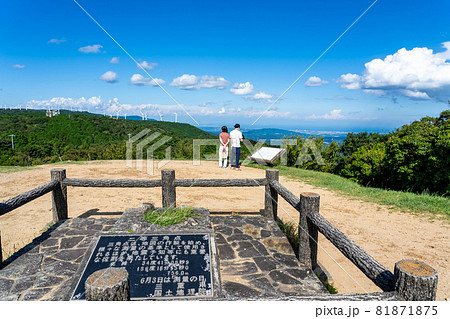 三重県津市 青山高原山頂にある二等三角点から下界を眺める人の写真素材 三重県津市 青山高原山頂にある二等三角点から下界を眺める人の写真素材