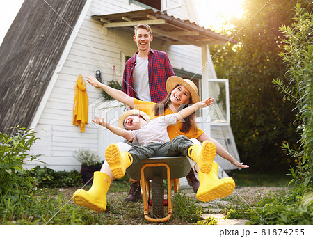 Excited family playing with wheelbarrow 81874255