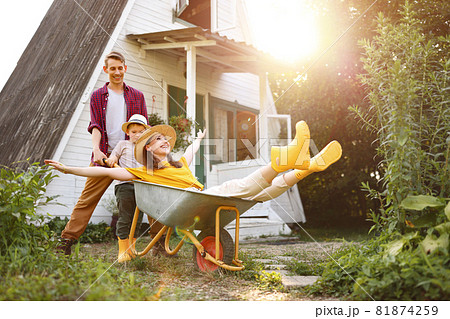 Excited family playing with wheelbarrow 81874259