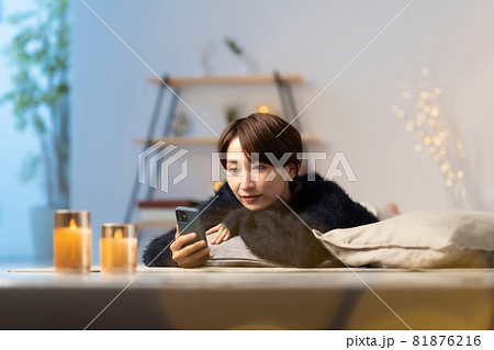ミドル女性　冬　くつろぐ　スマホ 81876216