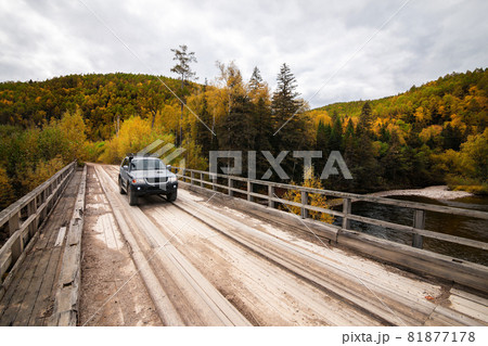 Mitsubishi Pajero Sport on wooden bridge in autumn forest Mitsubishi Pajero Sport on wooden bridge in autumn forest 81877178