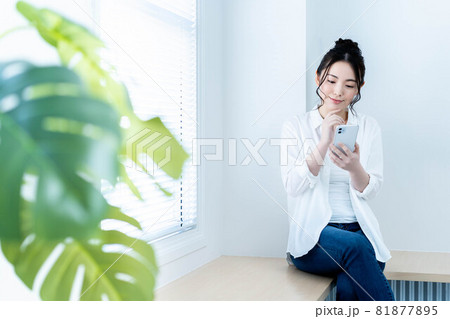 リビングでスマホを使う若い女性 81877895