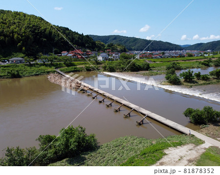 鳥の目線で見た大雨後の島根県雲南市木次町の斐伊川の堤防付近にある桜並木に隣接した潜水橋の願い橋 81878352