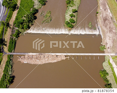 鳥の目線で見た大雨後の島根県雲南市木次町の斐伊川の堤防付近にある桜並木に隣接した潜水橋の願い橋 鳥の目線で見た大雨後の島根県雲南市木次町の斐伊川の堤防付近にある桜並木に隣接した潜水橋の願い橋 81878354