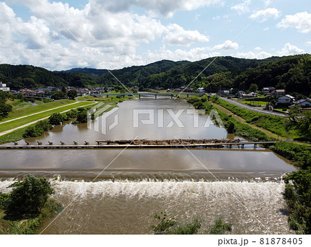 鳥の目線で見た大雨後の島根県雲南市木次町の斐伊川の堤防付近にある桜並木に隣接した潜水橋の願い橋 81878405