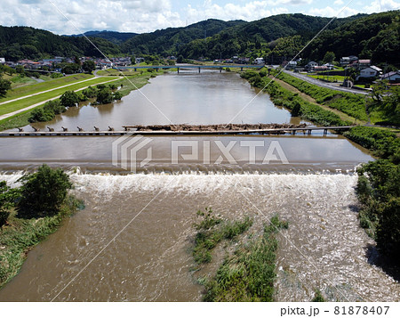 鳥の目線で見た大雨後の島根県雲南市木次町の斐伊川の堤防付近にある桜並木に隣接した潜水橋の願い橋 鳥の目線で見た大雨後の島根県雲南市木次町の斐伊川の堤防付近にある桜並木に隣接した潜水橋の願い橋 81878407