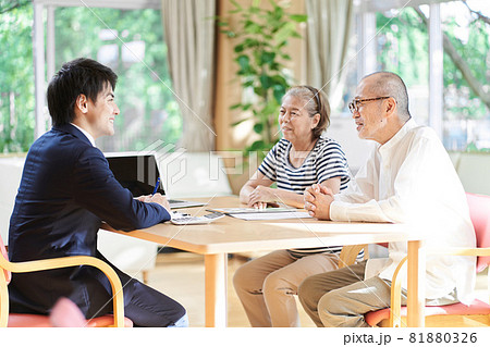 高齢者夫婦に不動産売買のアドバイスをするビジネスマン	 81880326