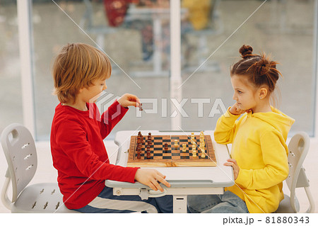 Little kids playing chess at kindergarten or elementary school. Children's chess play. Little kids playing chess at kindergarten or elementary school. Children's chess play. 81880343