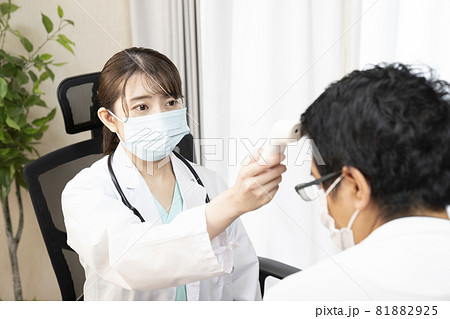 体温計で熱を測る女性医師 81882925