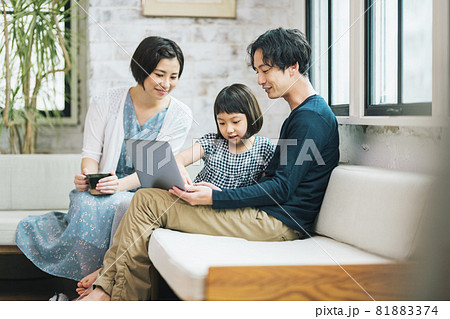 家のソファーでノートパソコンを見る家族 81883374