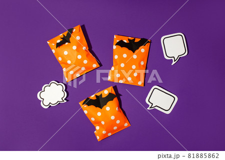 Halloween holiday concept with party gift paper bag decor and candy corn on bright violet purple backgtound, copy space, invitation, flyer, hard shadow, trendy concept Halloween holiday concept with party gift paper bag decor and candy corn on bright violet purple backgtound, copy space, invitation, flyer, hard shadow, trendy concept 81885862